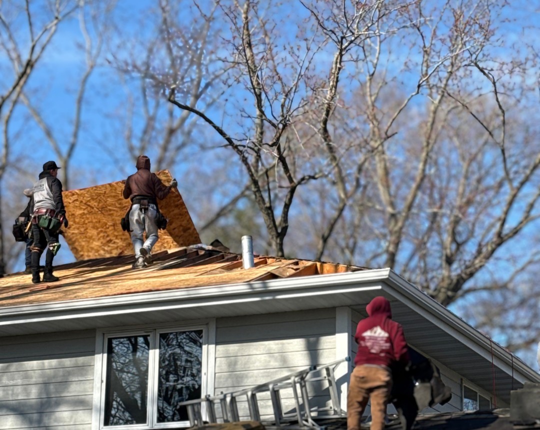 Roof replacement crew installing new roof decking on a home in Wayzata, MN